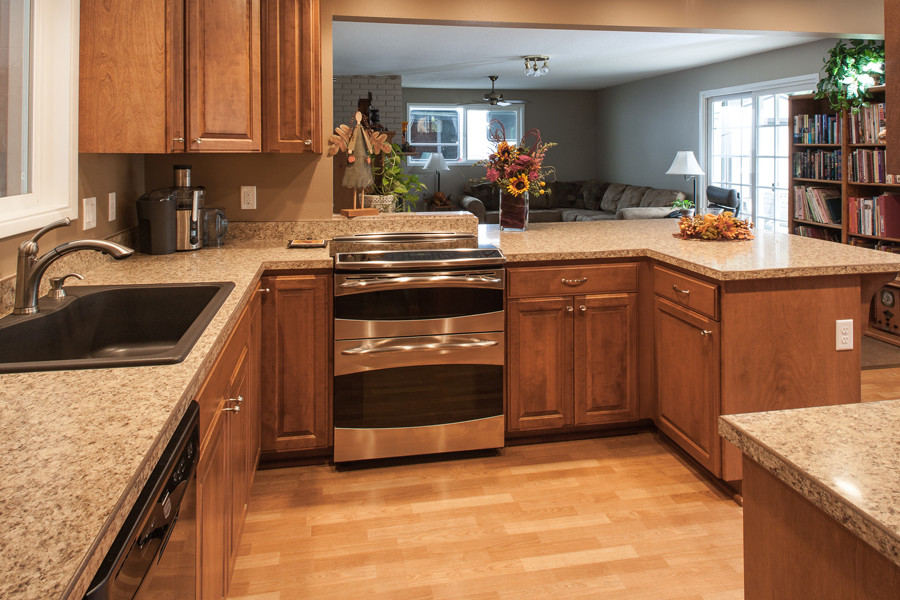Example of an arts and crafts l-shaped eat-in kitchen design in Portland with a drop-in sink, raised-panel cabinets, medium tone wood cabinets, multicolored backsplash and stainless steel appliances