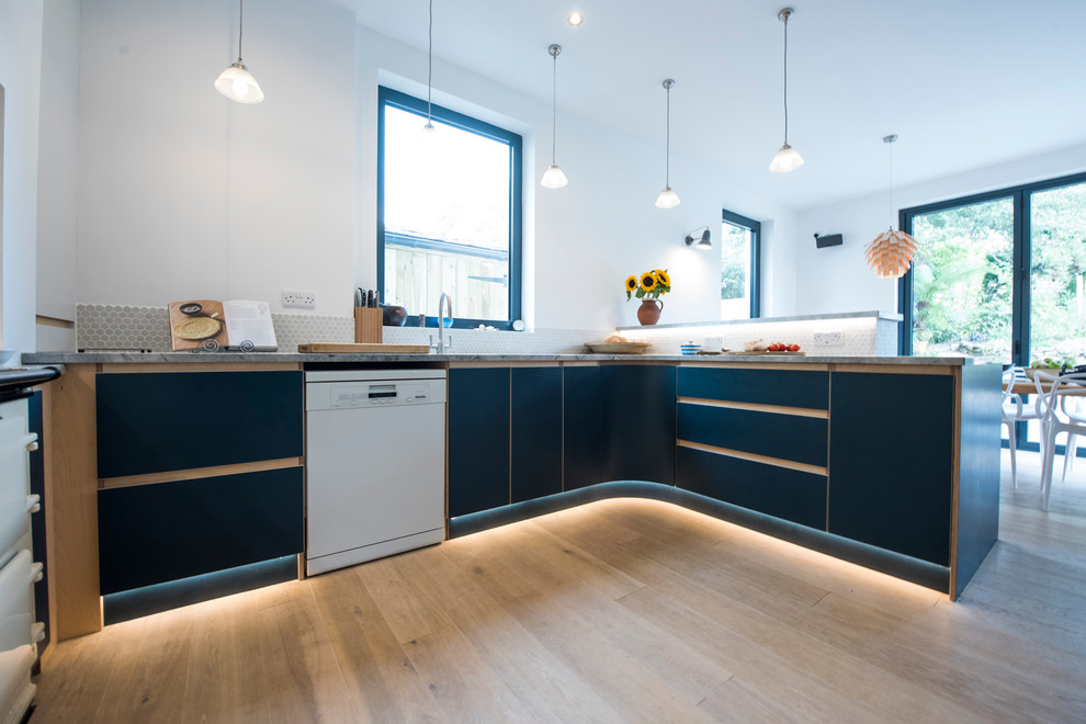 コーンウォールにある広いコンテンポラリースタイルのおしゃれなキッチン (青いキャビネット、亜鉛製カウンター、ベージュキッチンパネル、淡色無垢フローリング) の写真