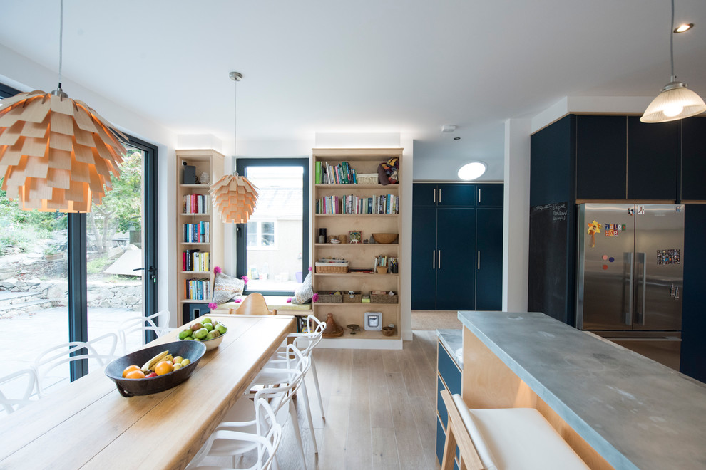 Große Moderne Küche mit flächenbündigen Schrankfronten, blauen Schränken, Zink-Arbeitsplatte, Küchenrückwand in Beige und hellem Holzboden in Cornwall