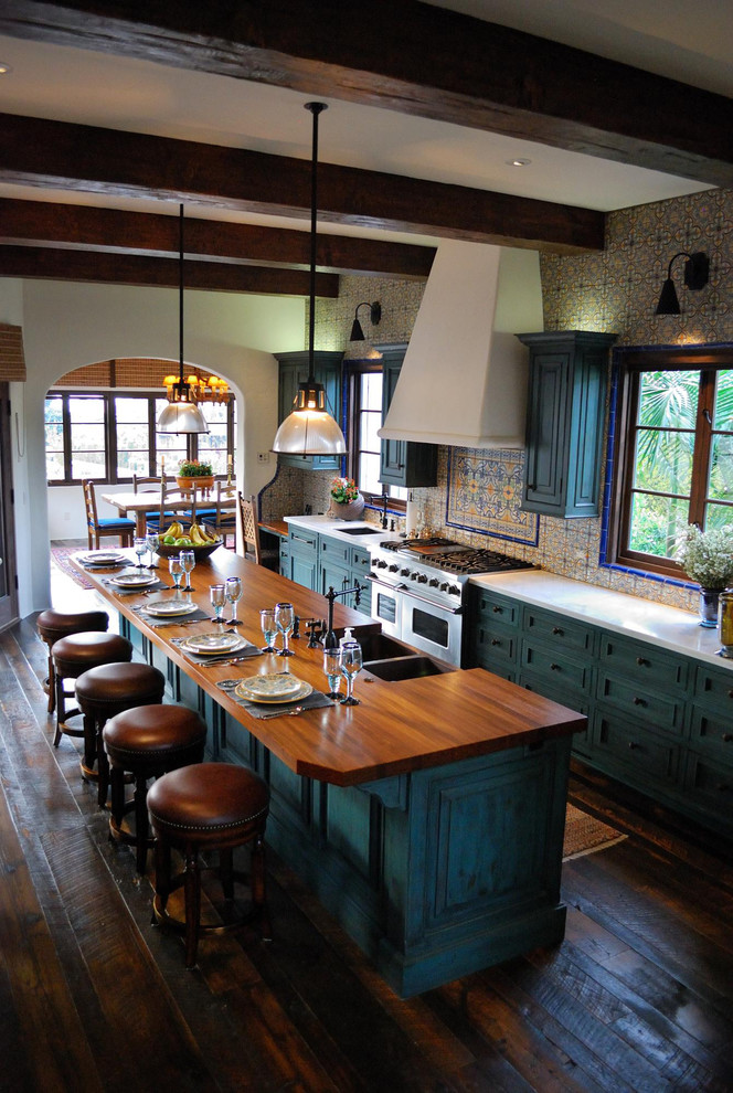 Bild på ett medelhavsstil kök med öppen planlösning, med en undermonterad diskho, luckor med upphöjd panel, gröna skåp, marmorbänkskiva, stänkskydd i keramik, integrerade vitvaror, mörkt trägolv och en köksö