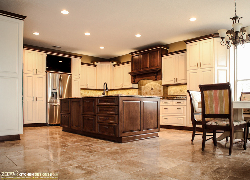 Example of a huge classic travertine floor eat-in kitchen design in Orlando with an undermount sink, raised-panel cabinets, white cabinets, granite countertops, beige backsplash, stone tile backsplash and an island