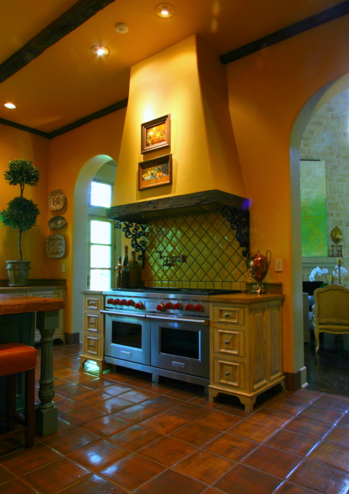 Inspiration for a huge mediterranean u-shaped terra-cotta tile enclosed kitchen remodel in Other with a farmhouse sink, beaded inset cabinets, white cabinets, concrete countertops, green backsplash, terra-cotta backsplash, stainless steel appliances and an island