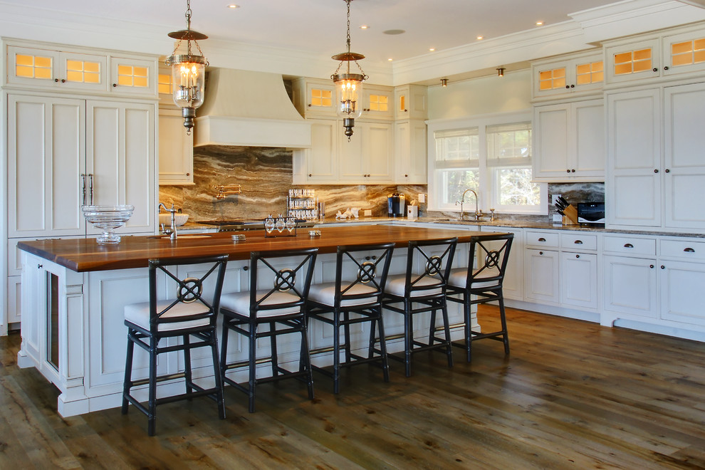 Inspiration for a large transitional l-shaped medium tone wood floor open concept kitchen remodel in Boston with an undermount sink, beaded inset cabinets, beige cabinets, granite countertops, brown backsplash, stone slab backsplash, paneled appliances and an island