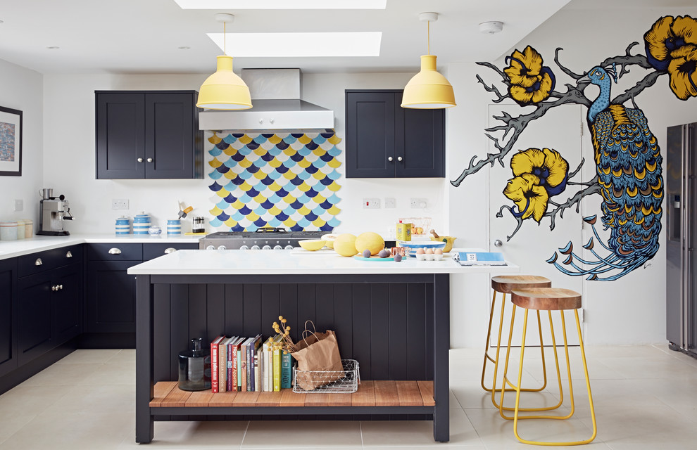 Стильный дизайн: угловая кухня-гостиная среднего размера в современном стиле с фасадами в стиле шейкер, синими фасадами, островом, разноцветным фартуком и бежевым полом - последний тренд