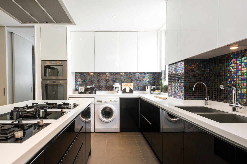 Moderne Küche mit Doppelwaschbecken, flächenbündigen Schrankfronten, schwarzen Schränken, Küchenrückwand in Metallic, Kücheninsel und grauem Boden in Hongkong