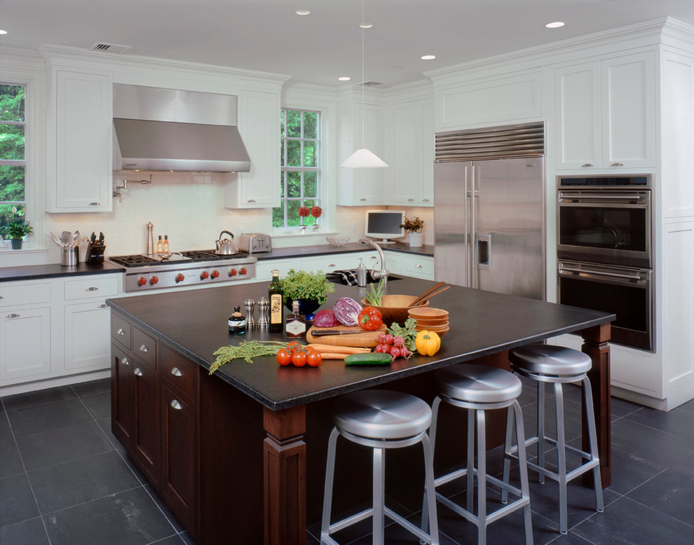 Example of a large trendy l-shaped porcelain tile eat-in kitchen design in New York with an undermount sink, recessed-panel cabinets, white cabinets, granite countertops, white backsplash, ceramic backsplash, stainless steel appliances and an island