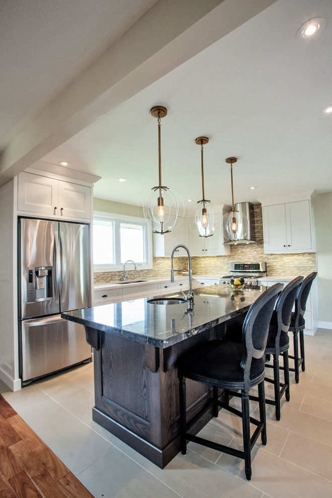 Idée de décoration pour une cuisine américaine tradition en L et bois foncé avec un évier encastré, un placard à porte shaker, un plan de travail en granite, une crédence jaune, une crédence en mosaïque et un électroménager en acier inoxydable.