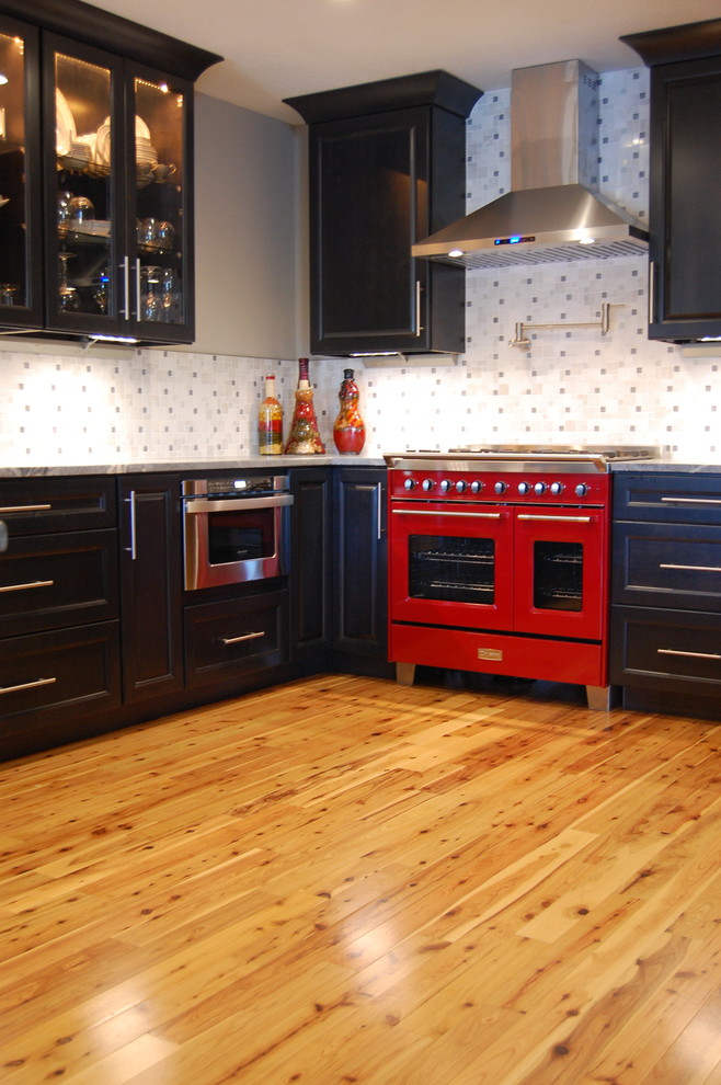 Photo of a large traditional l-shaped kitchen in Sacramento with recessed-panel cabinets, black cabinets, grey splashback, coloured appliances, medium hardwood flooring and brown floors.