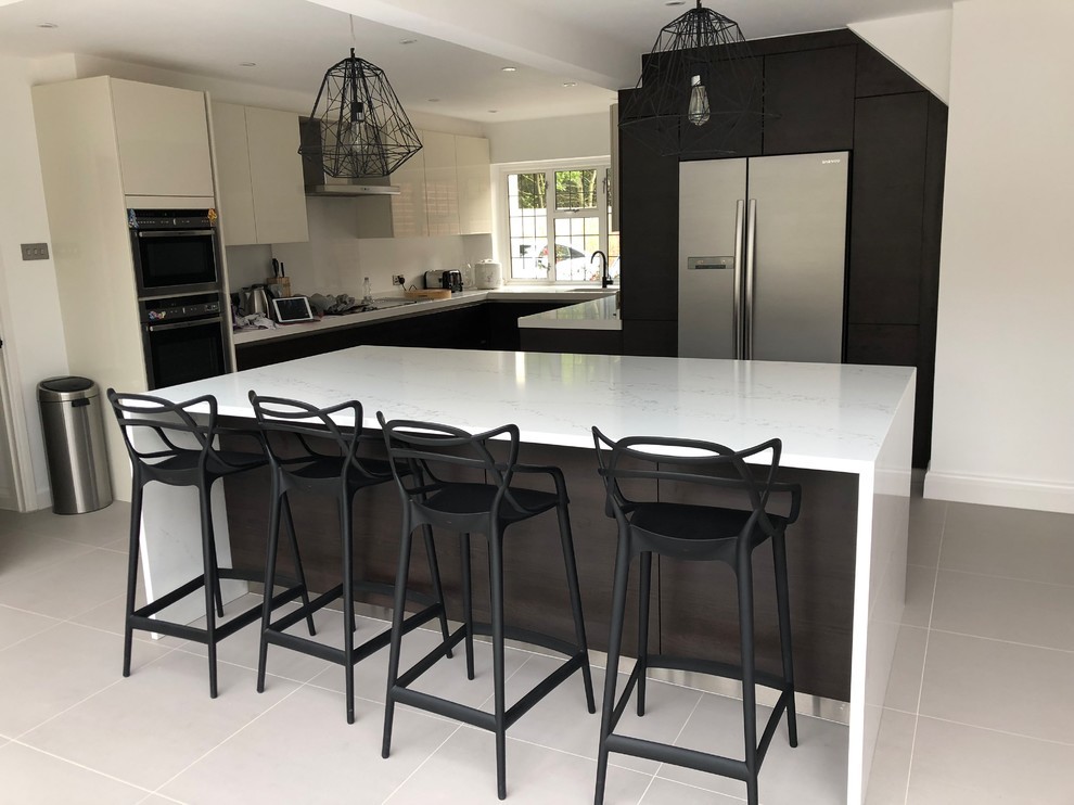 Inspiration for a medium sized contemporary open plan kitchen in London with flat-panel cabinets, brown cabinets, quartz worktops, stainless steel appliances, an island and beige floors.