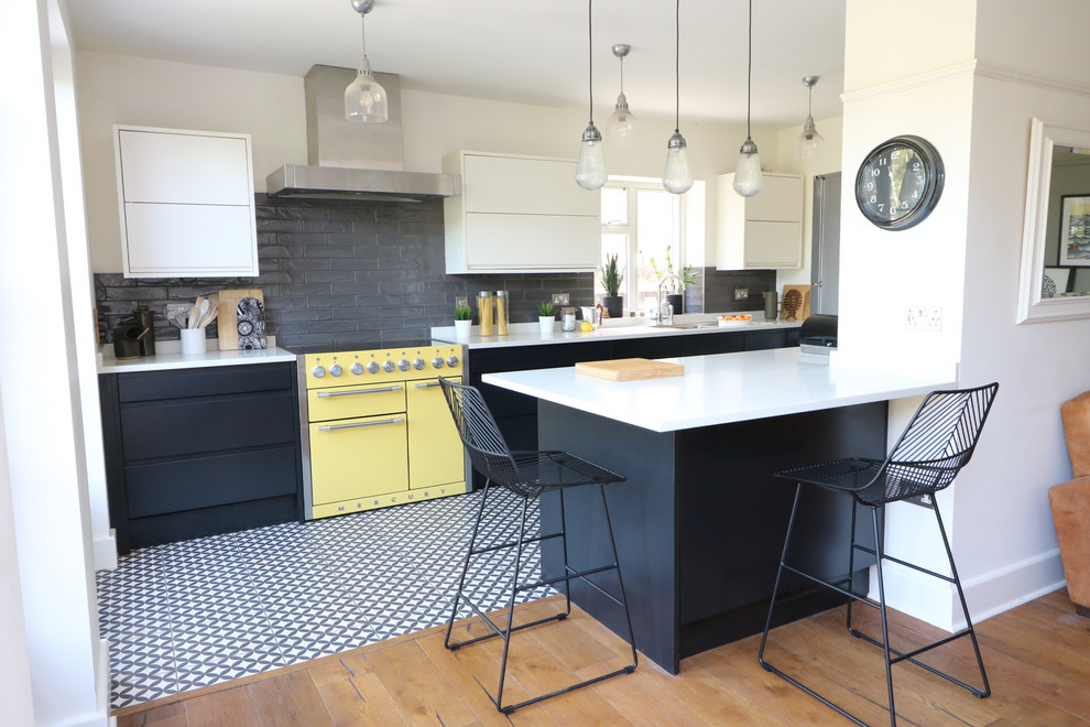 Modern inredning av ett stort vit vitt kök och matrum, med släta luckor, svarta skåp, bänkskiva i kvartsit, grått stänkskydd, stänkskydd i keramik, klinkergolv i keramik och flerfärgat golv