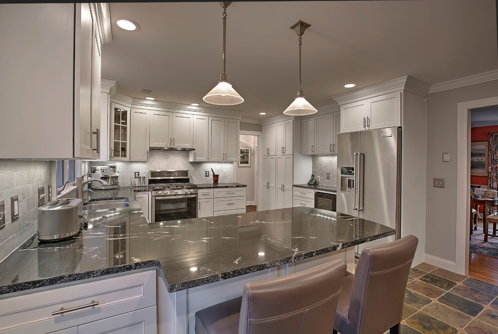 Mid-sized transitional u-shaped slate floor and multicolored floor eat-in kitchen photo in New York with an undermount sink, recessed-panel cabinets, white cabinets, granite countertops, gray backsplash, subway tile backsplash, stainless steel appliances and a peninsula