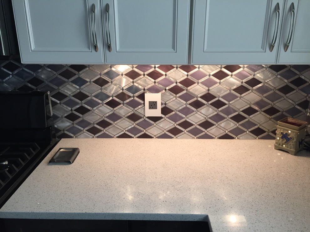 Mid-sized trendy l-shaped porcelain tile enclosed kitchen photo in Cleveland with an undermount sink, quartzite countertops, metallic backsplash, stainless steel appliances and a peninsula