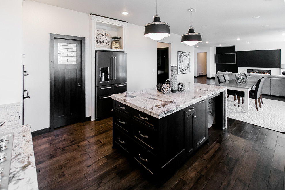 Large transitional l-shaped dark wood floor and brown floor open concept kitchen photo in Other with an undermount sink, shaker cabinets, white cabinets, granite countertops, white backsplash, subway tile backsplash, stainless steel appliances and an island