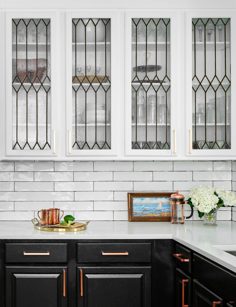 Kitchen - mid-sized traditional l-shaped medium tone wood floor and brown floor kitchen idea in Austin with an undermount sink, raised-panel cabinets, quartz countertops, white backsplash, subway tile backsplash, stainless steel appliances, no island and white countertops