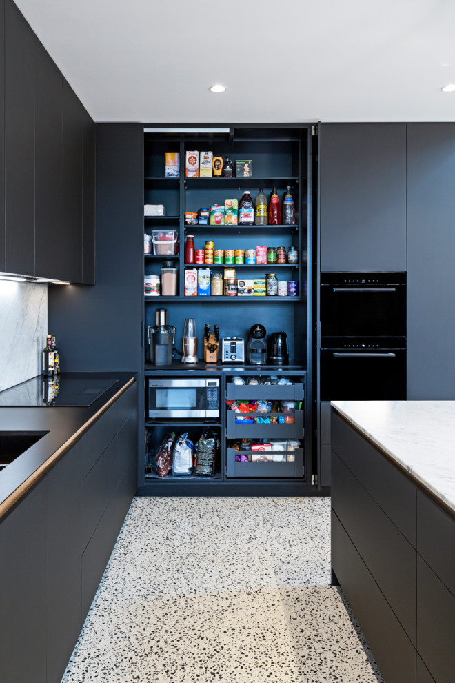 Idee per una cucina design di medie dimensioni con ante lisce, ante nere, top in marmo, paraspruzzi in marmo, elettrodomestici neri e pavimento in cemento