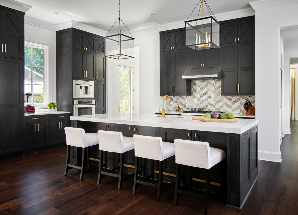 This is an example of an expansive open plan kitchen with a submerged sink, recessed-panel cabinets, black cabinets, stainless steel appliances, dark hardwood flooring, an island and white worktops.