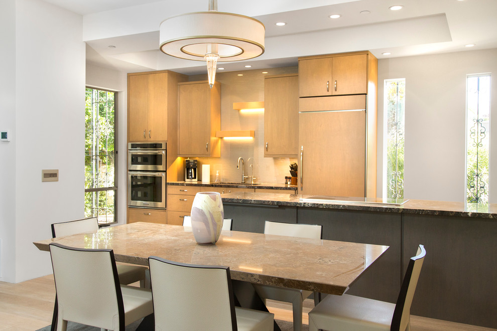 Inspiration for a large contemporary galley light wood floor eat-in kitchen remodel in Phoenix with an undermount sink, flat-panel cabinets, light wood cabinets, granite countertops, white backsplash, stone slab backsplash, paneled appliances and a peninsula