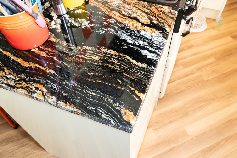 Modern kitchen in Hertfordshire with granite worktops and multicoloured worktops.