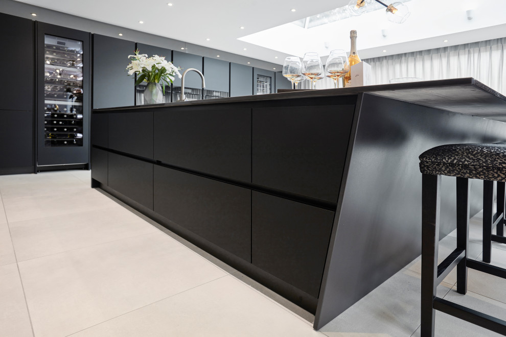 Design ideas for a large contemporary u-shaped open plan kitchen in Other with a single-bowl sink, flat-panel cabinets, black cabinets, engineered stone countertops, black splashback, black appliances, porcelain flooring, multiple islands, grey floors and black worktops.