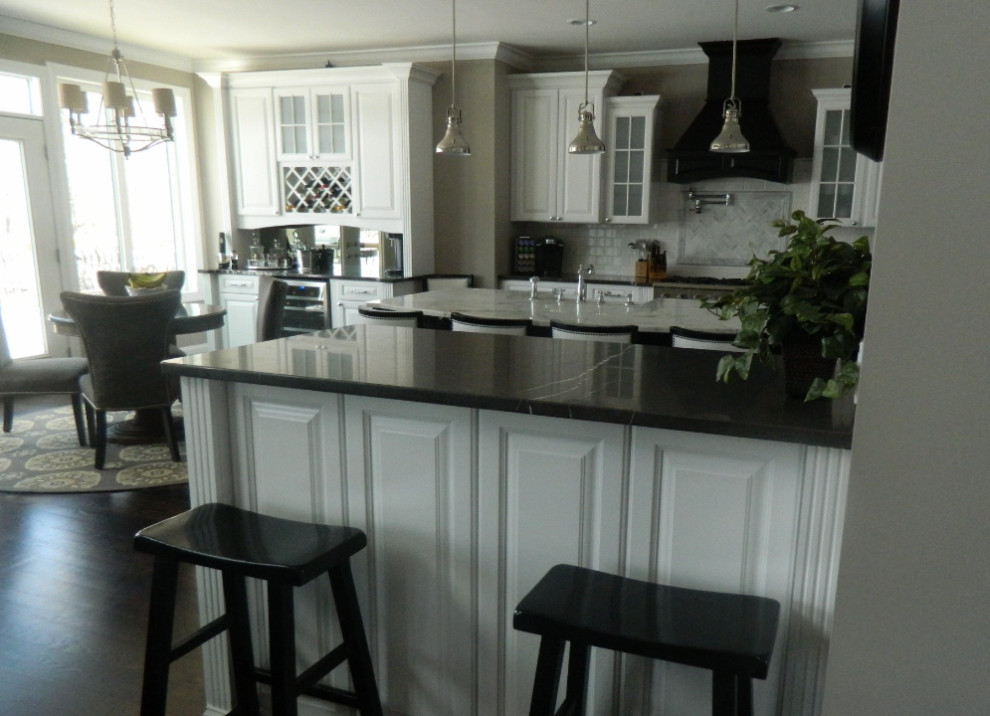 Foto di una cucina design di medie dimensioni con ante con bugna sagomata, ante bianche, paraspruzzi bianco, elettrodomestici in acciaio inossidabile, parquet scuro e top multicolore