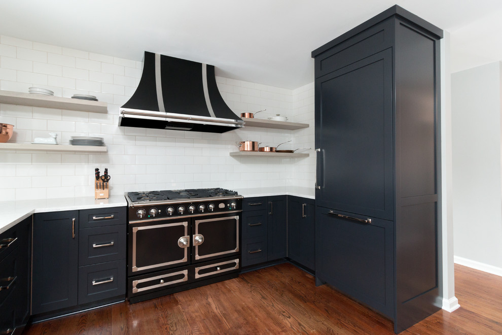 Idéer för ett litet modernt kök, med en rustik diskho, skåp i shakerstil, svarta skåp, bänkskiva i kvarts, vitt stänkskydd, stänkskydd i tunnelbanekakel, svarta vitvaror och mellanmörkt trägolv