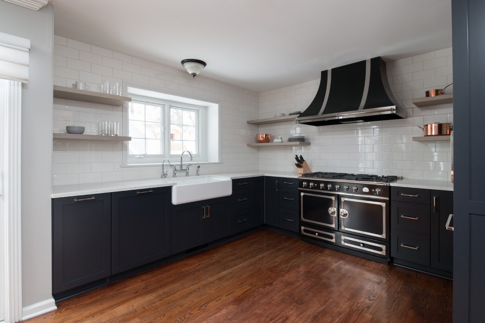 Idéer för att renovera ett litet funkis kök, med en rustik diskho, skåp i shakerstil, svarta skåp, bänkskiva i kvarts, vitt stänkskydd, stänkskydd i tunnelbanekakel, svarta vitvaror och mellanmörkt trägolv