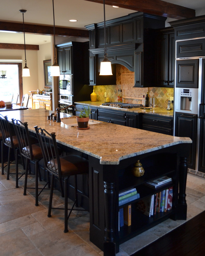 Bild på ett mellanstort vintage beige linjärt beige kök och matrum, med en undermonterad diskho, luckor med upphöjd panel, svarta skåp, granitbänkskiva, integrerade vitvaror, en köksö, stänkskydd i stenkakel och travertin golv