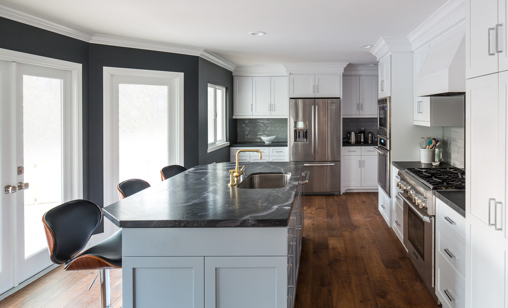 Exempel på ett stort klassiskt kök, med en undermonterad diskho, skåp i shakerstil, grå skåp, marmorbänkskiva, grått stänkskydd, stänkskydd i porslinskakel, rostfria vitvaror, mellanmörkt trägolv och en köksö