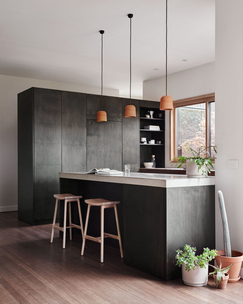 Imagen de cocina contemporánea con armarios con paneles lisos, puertas de armario de madera en tonos medios, suelo de madera en tonos medios y encimeras blancas
