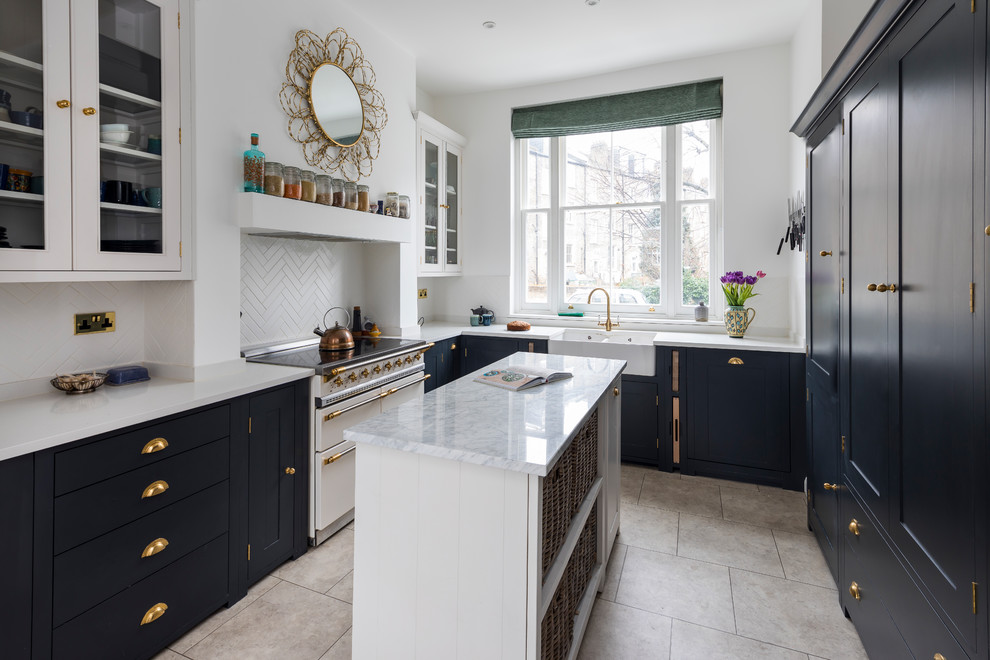 Photo of a small traditional l-shaped kitchen/diner in London with a belfast sink, shaker cabinets, black cabinets, quartz worktops, limestone flooring, an island, beige floors, white splashback and white appliances.