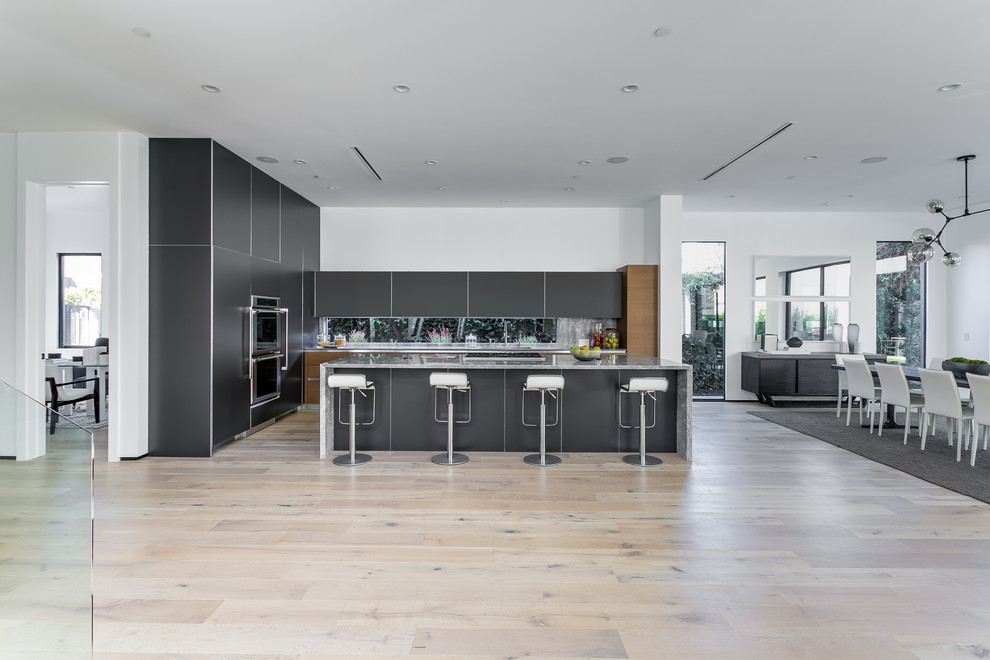 Immagine di una cucina minimalista con lavello a doppia vasca, ante lisce, ante nere, top in marmo, paraspruzzi multicolore, elettrodomestici in acciaio inossidabile e pavimento in legno massello medio