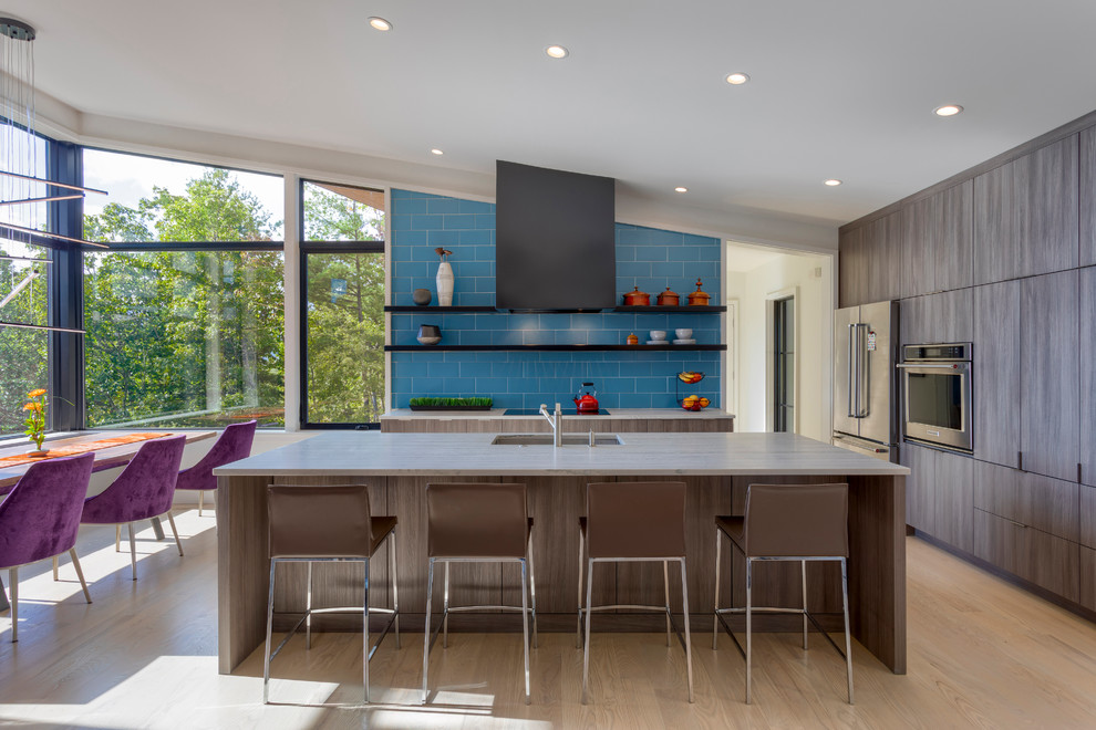 Contemporary u-shaped kitchen/diner in Other with a submerged sink, flat-panel cabinets, brown cabinets, blue splashback, stainless steel appliances, light hardwood flooring, an island, beige floors and white worktops.