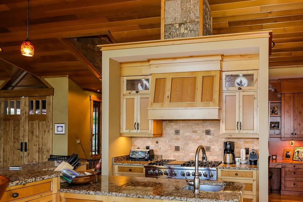 Foto på ett stort amerikanskt linjärt kök och matrum, med en enkel diskho, luckor med profilerade fronter, skåp i ljust trä, granitbänkskiva, beige stänkskydd, stänkskydd i stenkakel, rostfria vitvaror, mellanmörkt trägolv och en köksö