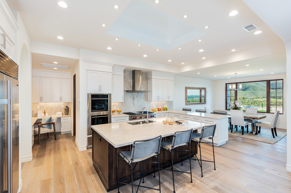Inspiration for a transitional light wood floor and beige floor eat-in kitchen remodel in San Diego with an undermount sink, recessed-panel cabinets, white cabinets and stainless steel appliances