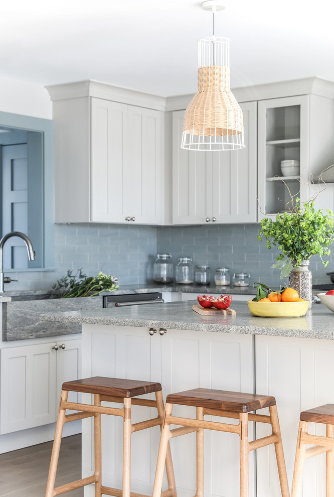Mid-sized minimalist l-shaped medium tone wood floor open concept kitchen photo in Portland Maine with an integrated sink, shaker cabinets, gray cabinets, granite countertops, blue backsplash, brick backsplash, stainless steel appliances, an island and gray countertops