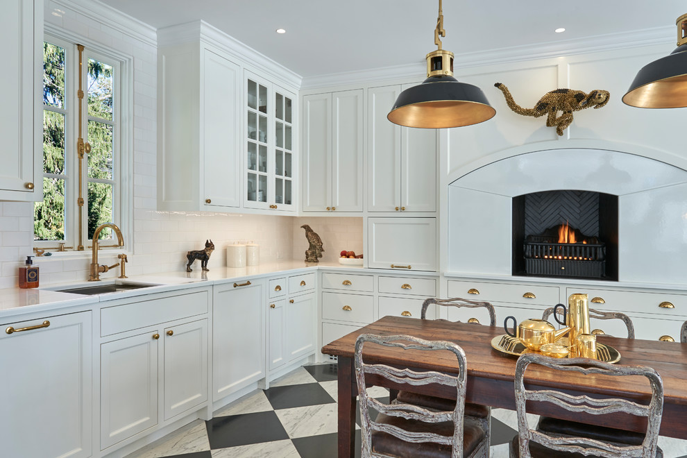 This is an example of a traditional cream and black l-shaped kitchen in New York with recessed-panel cabinets, composite countertops, ceramic splashback, marble flooring, white worktops, a submerged sink, white cabinets, white splashback, an island and multi-coloured floors.