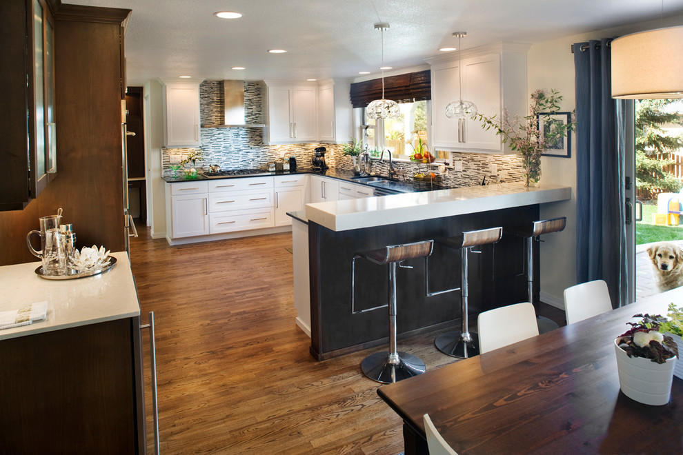 Example of a mid-sized trendy u-shaped medium tone wood floor eat-in kitchen design in Boise with an undermount sink, recessed-panel cabinets, white cabinets, quartz countertops, multicolored backsplash, matchstick tile backsplash, stainless steel appliances and no island