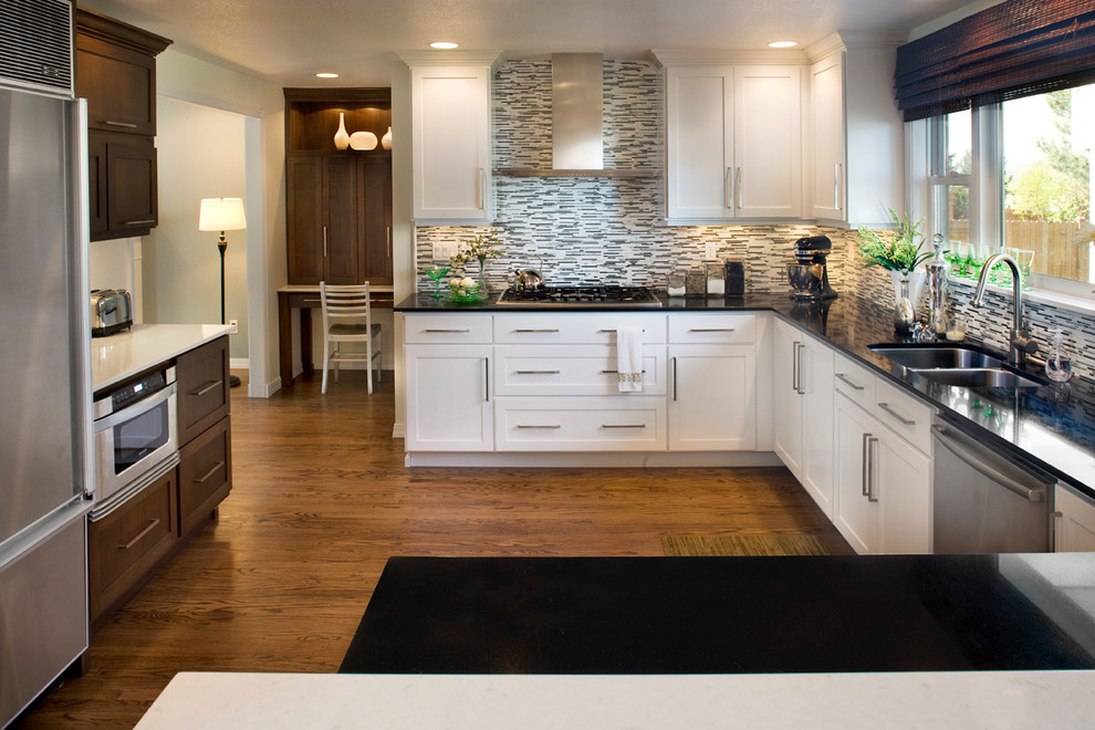 Foto på ett mellanstort funkis kök, med en undermonterad diskho, luckor med infälld panel, vita skåp, bänkskiva i kvarts, flerfärgad stänkskydd, stänkskydd i stickkakel, rostfria vitvaror och mellanmörkt trägolv