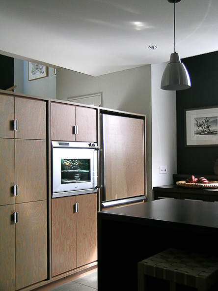 Idéer för ett mellanstort modernt u-kök, med en nedsänkt diskho, släta luckor, skåp i mellenmörkt trä, laminatbänkskiva, svart stänkskydd, rostfria vitvaror, betonggolv och en köksö