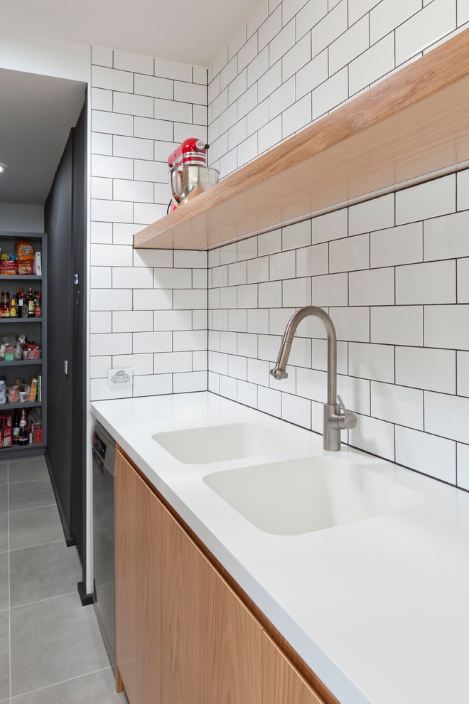 Inspiration for a mid-sized contemporary galley cement tile floor eat-in kitchen remodel in Melbourne with an undermount sink, raised-panel cabinets, light wood cabinets, granite countertops, gray backsplash, glass sheet backsplash, stainless steel appliances and no island