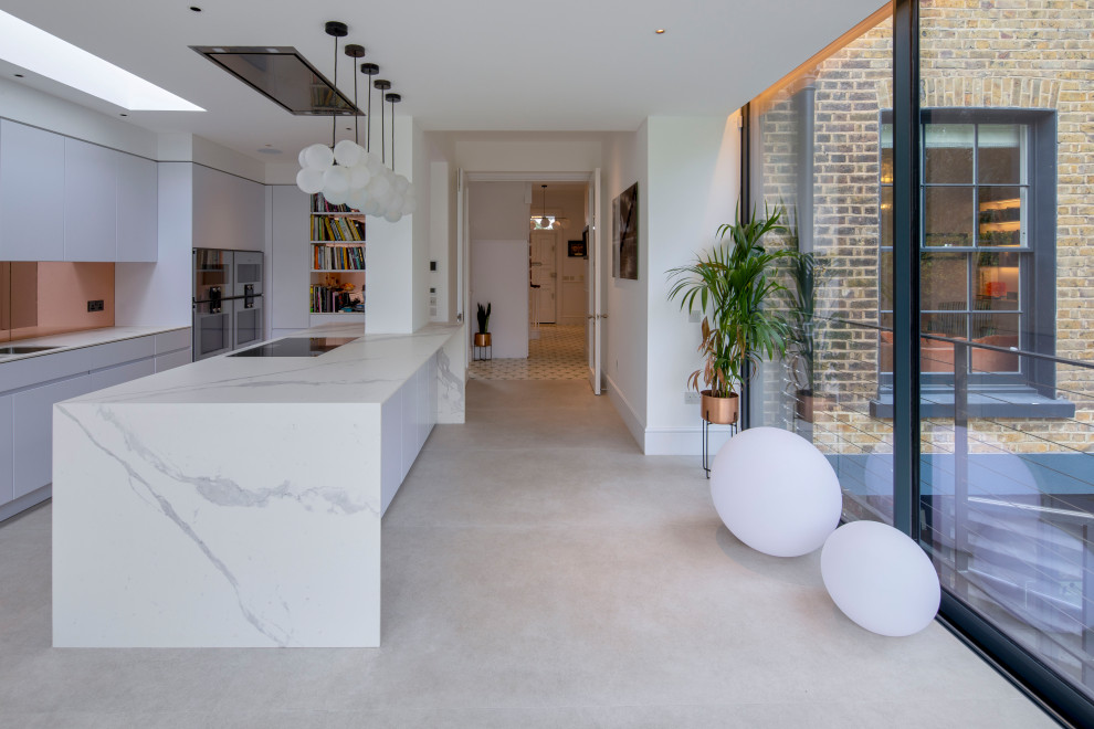 Moderne Küche mit flächenbündigen Schrankfronten, weißen Schränken, Elektrogeräten mit Frontblende, Betonboden, Kücheninsel und grauem Boden in London