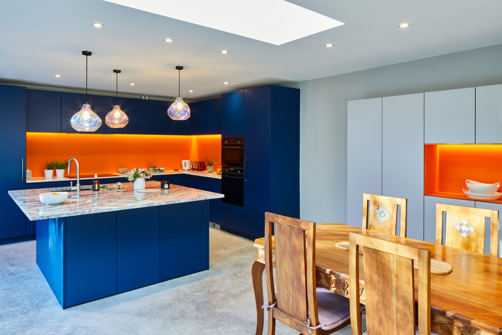 Inspiration for a large contemporary l-shaped concrete floor and gray floor eat-in kitchen remodel in London with flat-panel cabinets, blue cabinets, quartzite countertops, orange backsplash, glass sheet backsplash, stainless steel appliances and an island