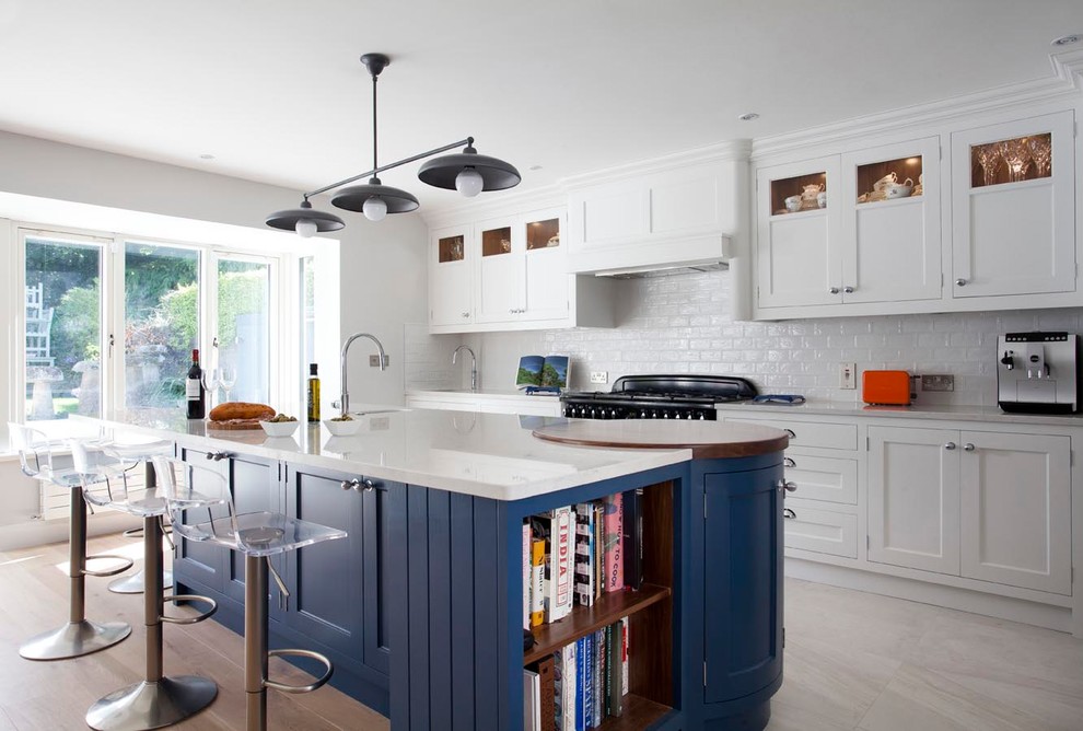 Large beach style galley light wood floor and beige floor open concept kitchen photo in Dublin with shaker cabinets, blue cabinets, quartzite countertops, ceramic backsplash, black appliances, an island and an undermount sink