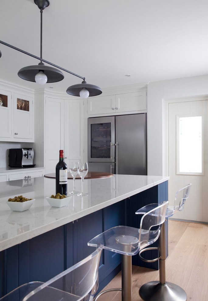 Immagine di una grande cucina design con lavello integrato, ante in stile shaker, ante blu, top in quarzite, paraspruzzi con piastrelle in ceramica, elettrodomestici neri, parquet chiaro e pavimento marrone