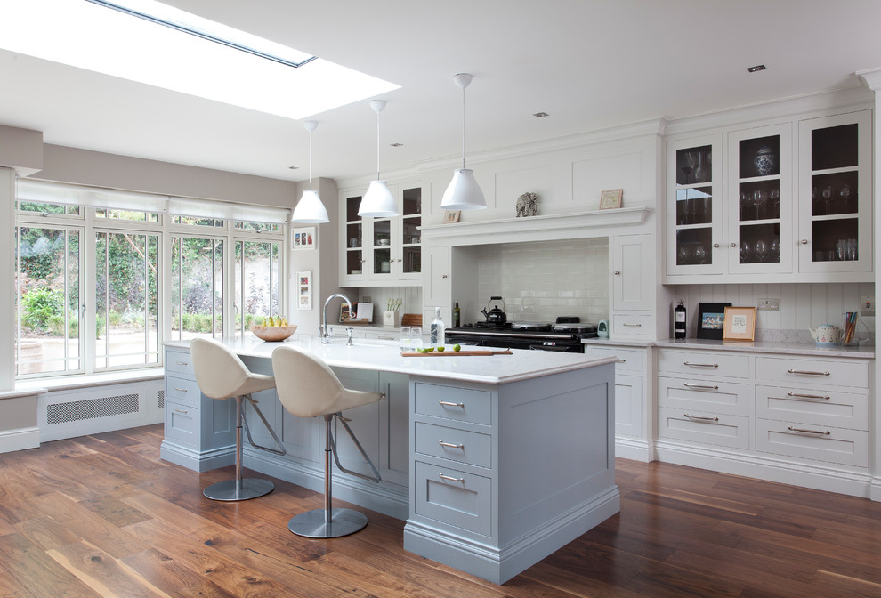 Zweizeilige Klassische Küche mit Schrankfronten im Shaker-Stil, weißen Schränken, Küchenrückwand in Weiß, Rückwand aus Metrofliesen, dunklem Holzboden und Kücheninsel in Dublin
