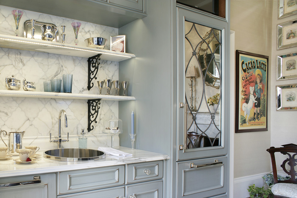 Bild på ett litet vintage kök, med en nedsänkt diskho, rostfria vitvaror, mellanmörkt trägolv, en köksö, luckor med infälld panel, marmorbänkskiva, vitt stänkskydd, stänkskydd i mosaik och grå skåp