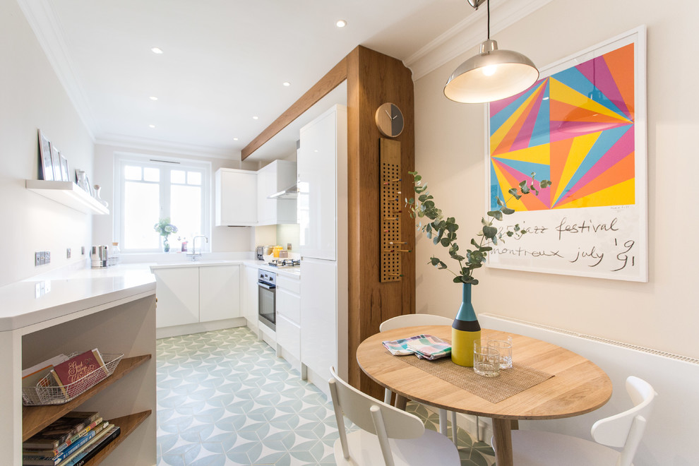 Nordische Wohnküche ohne Insel in U-Form mit flächenbündigen Schrankfronten, weißen Schränken und grünem Boden in London