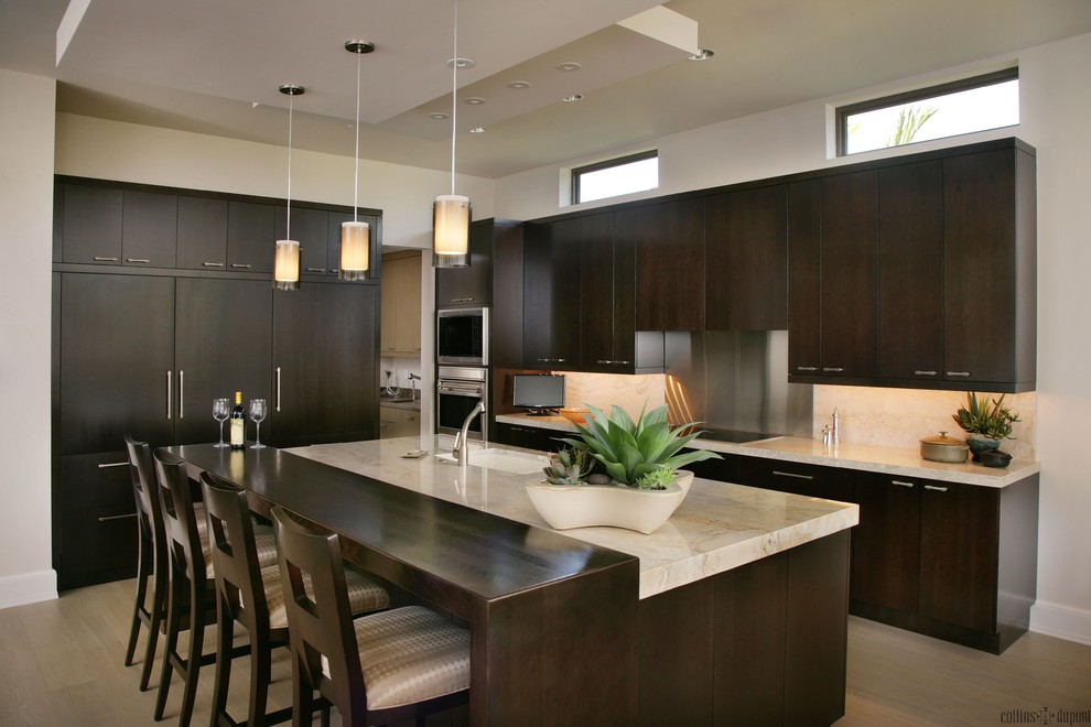 Immagine di una cucina design di medie dimensioni con lavello sottopiano, ante lisce e elettrodomestici in acciaio inossidabile