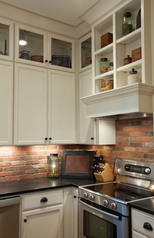 Eat-in kitchen - small craftsman l-shaped eat-in kitchen idea in Louisville with recessed-panel cabinets, white cabinets, brown backsplash, stainless steel appliances and an island