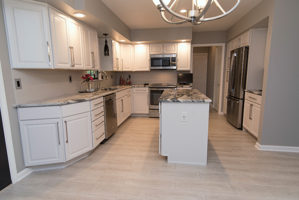 Example of a mid-sized trendy u-shaped ceramic tile and gray floor eat-in kitchen design in Baltimore with an undermount sink, raised-panel cabinets, white cabinets, granite countertops, white backsplash, ceramic backsplash, stainless steel appliances and an island